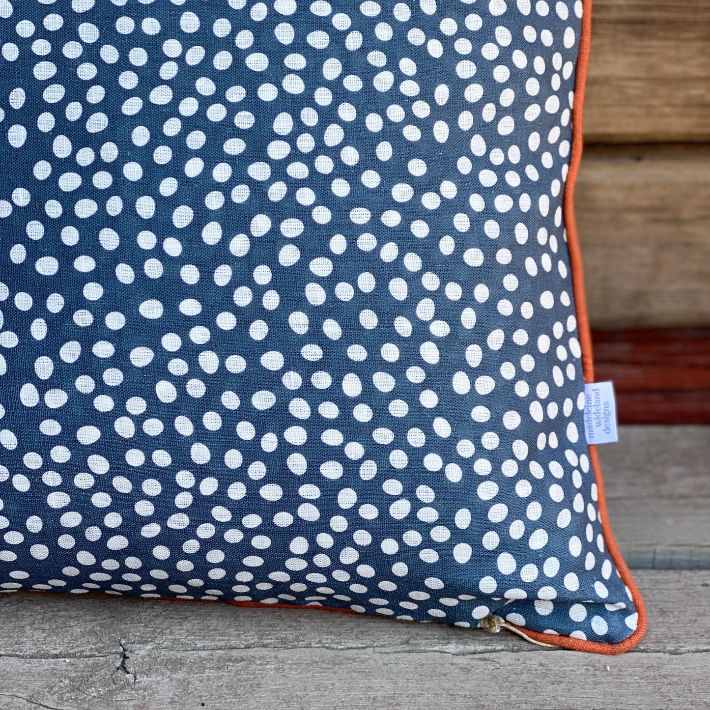 Dotty blå kuddfodral med orange passpoal 50x50 cm